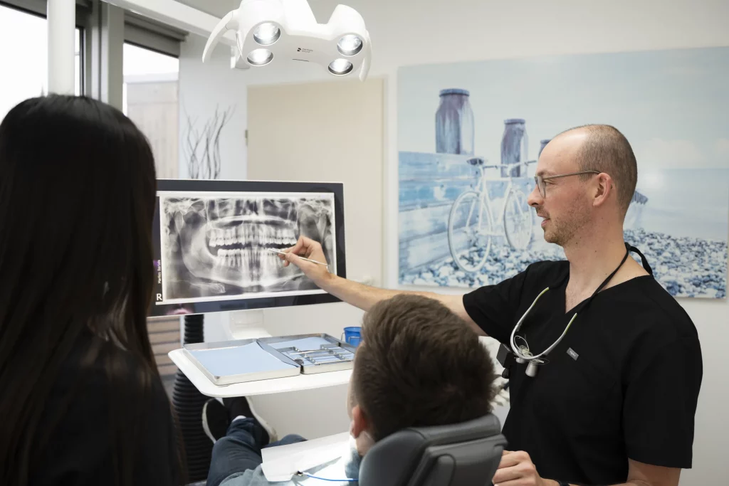 Dr. Philipp Bartels erklärt einem Patienten eine Röntgenaufnahme