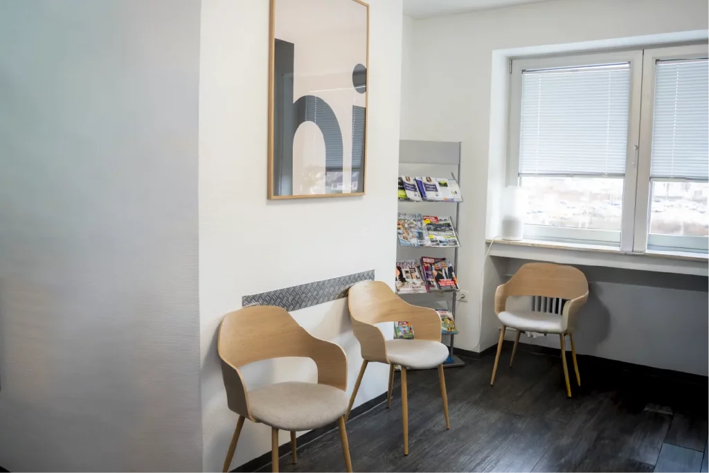 Heller Wartebereich der Zahnarztpraxis Zahnfreunde Euskirchen mit Sitzgelegenheiten und Zeitschriften.